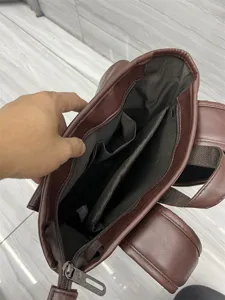 Brown PU leather backpack interior detail showing multiple compartments and lining structure.
