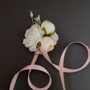 Delicate pink and white artificial flower corsage detail with soft ribbons for weddings.