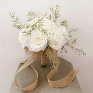 Détail du bouquet de mariée en roses artificielles blanches avec ruban en jute élégant.