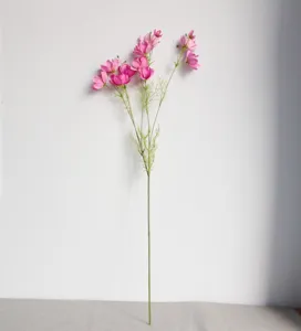 Detailed view of the artificial cosmos flower stem, featuring delicate pink petals and green leaves.