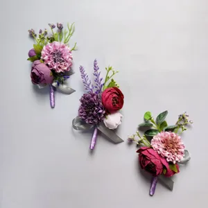 Detailed view of elegant purple and pink artificial boutonnieres with silver ribbons for wedding groom.
