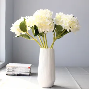 Fiori di ortensia bianca artificiali in un vaso bianco per decorazione domestica e oggetti.