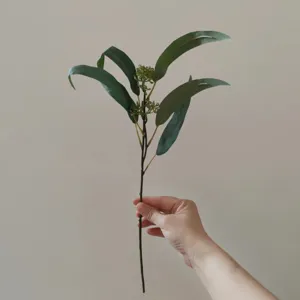 Vista dettagliata di ramo di eucalipto artificiale con foglie e bacche per decorazione casa.