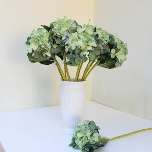 Ortensia artificiale in seta vista di dettaglio, realistico decoro floreale verde per casa e sfondo fotografico.