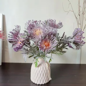 Vista dettagliata di fiori artificiali floccati a cuscino in vaso di ceramica rosa per arredo.
