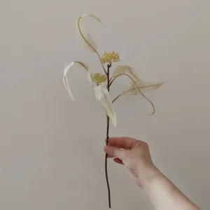 Rametto di eucalipto artificiale con foglie e piccoli frutti per decorazione domestica e matrimoni.