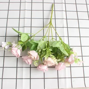 Vista dettagliata di un bouquet di rose rosa artificiali, fiori di seta con foglie per decorazione.