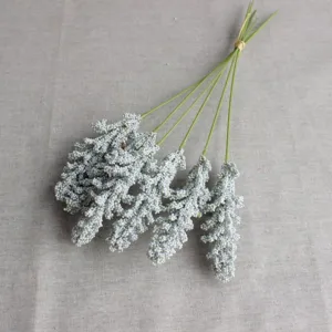 Close up detail view of artificial vanilla spike flower branches with green stems and foam berries.