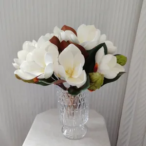 Bouquet de fleurs de magnolia artificielles avec vase en verre pour décoration intérieure.