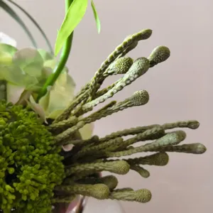 Close-up detail of artificial flower bouquet, handmade green silk floral decor for home.