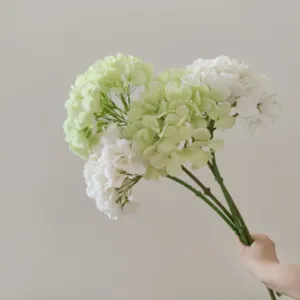 Primo piano di un ramo di ortensia artificiale, decorazione floreale in seta verde e bianca.
