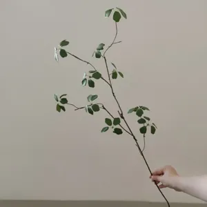 Close-up detail of artificial green plant leaf branch for home decor and floral arrangement.