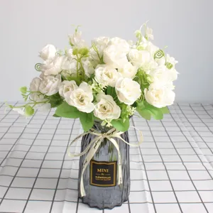 Bouquet di piccoli fiori di rose artificiali con vaso in vetro grigio per decorazione