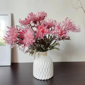 Primo piano di fiori artificiali di cuscinetto in un vaso di ceramica bianca per arredo.