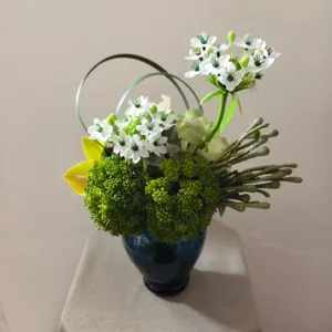 Close-up of artificial flower bouquet in blue vase, perfect for home decor styling props.
