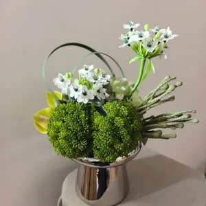 Artificial flower bouquet detail, modern mixed floral arrangement with silver vase decor.