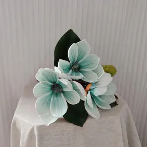 Détail de fleur de magnolia artificielle, décoration florale en soie sarcelle pour intérieur.