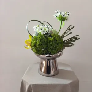 Detailed view of artificial floral arrangement in silver vase for home decor and photography.