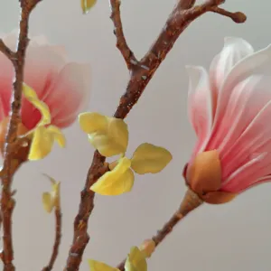 Detailed view of artificial magnolia flower branch, realistic EVA touch home decoration.
