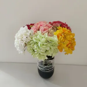 Primo piano di un colorato bouquet di ortensie artificiali in vaso scuro per decorazione.