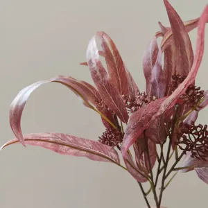 Dettaglio di ramo di eucalipto artificiale, foglie rosa autunnali per decorazioni domestiche.