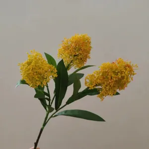Artificial skimmia flower detail shot, 3 yellow flower heads with green leaves for decor.
