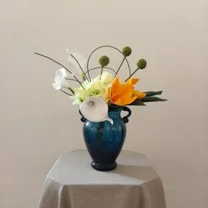 Gros plan détaillé de la composition florale artificielle en vase bleu pour décoration.