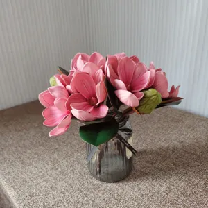 Bouquet de fleurs de magnolia artificielles avec vase en verre, détail décoration rose.