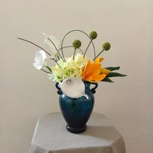 Superbe arrangement floral artificiel en vase bleu avec fleurs élégantes pour décoration.