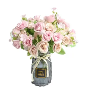 Bouquet di fiori di rose artificiali con vaso di vetro grigio per decorazione tavola.