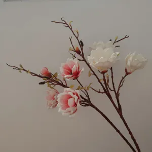 Detailed shot of artificial magnolia branch, realistic silk flower for home decor and styling.