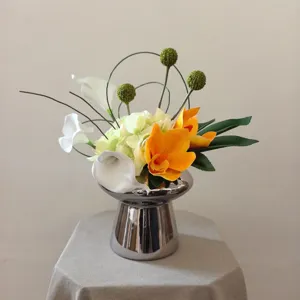 Gros plan de fleurs artificielles de luxe avec vase en métal argenté, décoration d'intérieur.