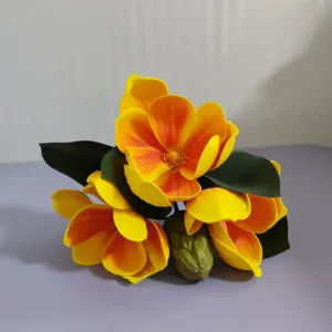 Détail du bouquet de fleurs de magnolia artificielles aux pétales dégradés jaune orange.