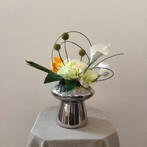 Gros plan d'un arrangement de fleurs artificielles dans un vase argenté pour décoration.