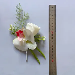 Artificial orchid rose corsage boutonniere wedding bridal floral accessory with metal ruler.
