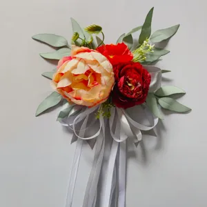 Detailed view of artificial floral decoration with pink peony and ribbons for wedding.