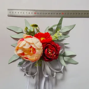 Artificial flower detail shot, wedding chair back floral decor with ribbon and leaves.