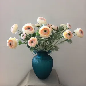 Vista dettagliata di un bouquet di ranuncoli artificiali in vaso blu, arredamento.