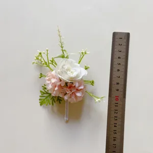 Künstliche rosa und weiße Blume Boutonniere Hochzeitskorsage mit grünen Blättern.