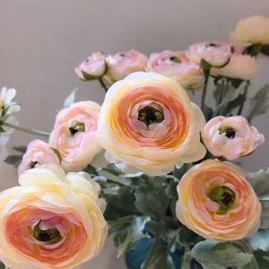 Vista ravvicinata di dettaglio di bouquet di fiori artificiali in seta di ranuncolo rosa e giallo.