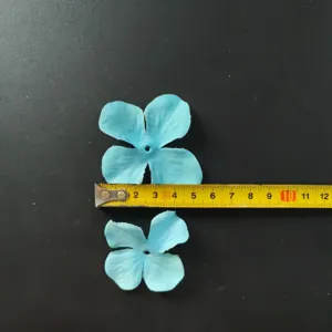 Close-up display of blue fabric hydrangea petals with measuring tape for DIY craft projects.