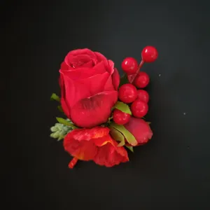 Red artificial rose corsage lapel flower detail for wedding groom suit decoration and party.