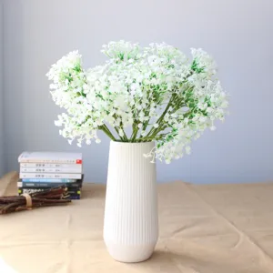 Bouquet di fiori di gipsofila artificiale con vaso in ceramica bianca per decorazione.