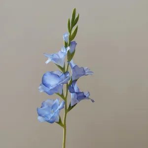 Close up detail of artificial blue gladiolus flower stem, showing delicate petal texture.