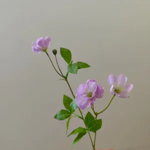 Detailaufnahme künstlicher Schmetterlings-Hahnenfuß-Blumenzweig mit grünen Blättern für DIY.