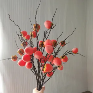 Primo piano di rami di cachi artificiali per decorazioni d'interni e composizioni.