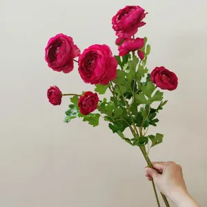 Detailed view of artificial magenta ranunculus flower bunch, silk floral prop for home decor.