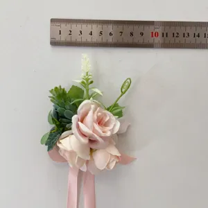 Pink artificial flower corsage with ribbon, wedding bridesmaid accessory for photography.