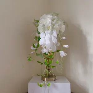 Gros plan détaillé du bouquet de mariée cascade en orchidées et roses artificielles.