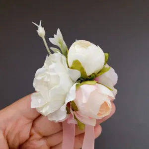Detailed close-up view of artificial flower wrist corsage with pink and white peonies.